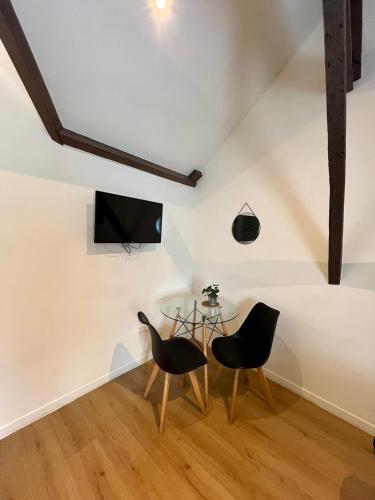 a dining room with two chairs and a glass table at Charme & calme en Centre ville à pied avec parking gratuit - Studio Oslo in Châtellerault