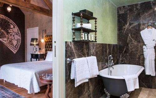 a bedroom with a bed and a bath tub at Château de l'Epinay in Saint-Georges-sur-Loire