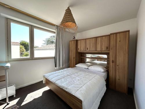 une chambre avec un grand lit avec une tête de lit en bois dans l'établissement Appartement 2 pièces, 4 couchages, centre Saint-Gilles-Croix-de-Vie, parking - FR-1-224-815, à Saint-Gilles-Croix-de-Vie