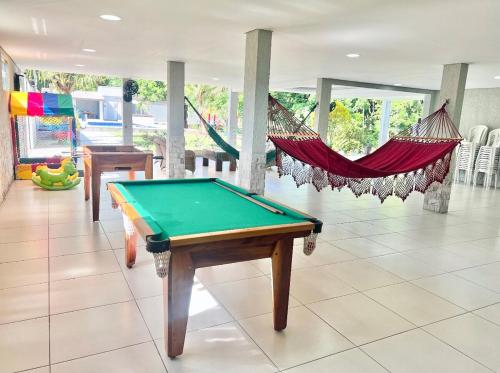 a pool table in a room with a hammock at Wakanda House Casa de veraneio in Magé
