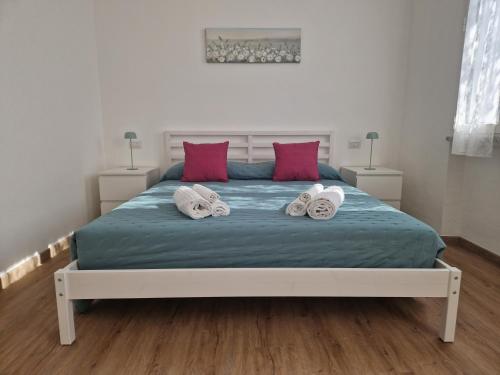 a bedroom with a large bed with two pairs of towels at Casa Felicita Garden Porto Frailis in Àrbatax