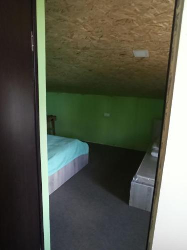 a small room with a bed and green walls at Загородный дом in Nurrnus