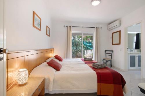 a bedroom with a large bed and a window at Villa Rose in Albufeira