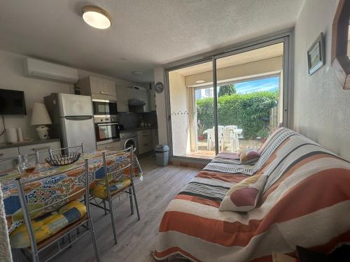 Cet appartement comprend une chambre avec un lit et une cuisine avec une fenêtre. dans l'établissement Le Ponant - Appartement proche du port et de la mer, à Gruissan