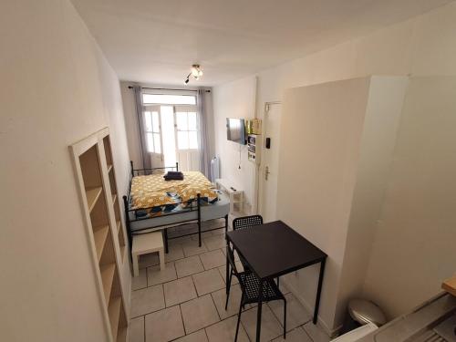 Cette petite chambre comprend une table et un lit. dans l'établissement Budgetbnb 180 centre ville, à Toulon