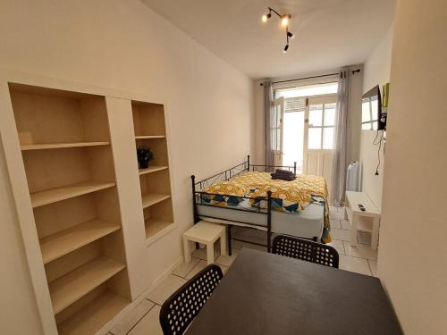 une petite pièce avec un lit, une table et des chaises dans l'établissement Budgetbnb 180 centre ville, à Toulon
