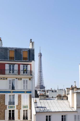 a view of the eiffel tower from behind buildings at Jardins Eiffel in Paris