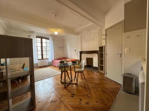 un salon avec une table et une chambre dans l'établissement Velhac domus - maison du velay, au Puy-en-Velay