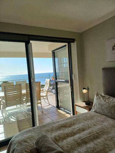 a bedroom with a bed and a view of the ocean at Point Village Accommodation - Santos 57 in Mossel Bay