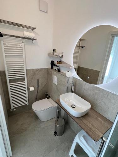 a bathroom with a sink and a toilet and a mirror at Cecia's House in Bassano del Grappa