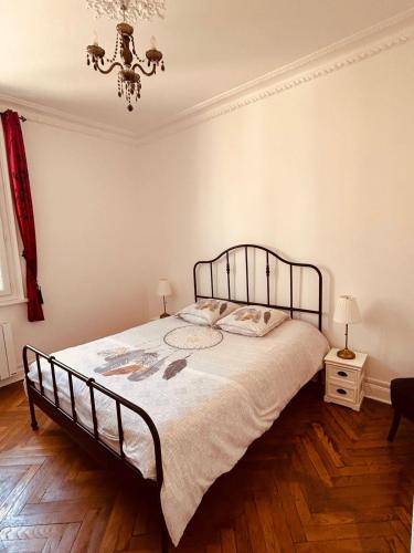 - une chambre avec un grand lit et un lustre dans l'établissement L'Atelier Normand, à Fécamp