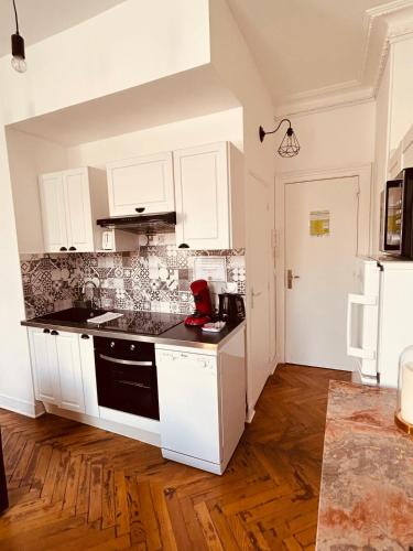 une cuisine avec des armoires blanches et un comptoir noir dans l'établissement L'Atelier Normand, à Fécamp