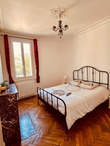 une chambre avec un lit et un lustre dans l'établissement L'Atelier Normand, à Fécamp