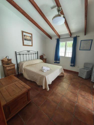 a bedroom with a bed and a table and a window at Casa Rural Martín in Canillas de Aceituno