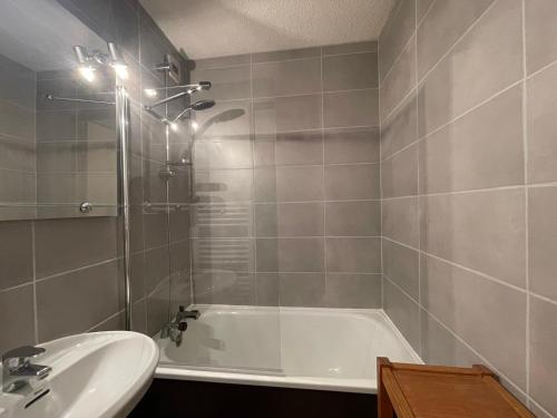 une salle de bain avec une baignoire et un lavabo dans l'établissement Appartement familial skis aux pieds avec parking à Samoëns 1600 - FR-1-624-15, à Samoëns