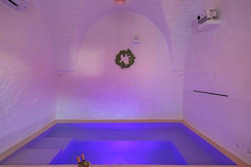 a purple room with a tub with purple lighting at Masseria Ramunno Piccola - Fiora Suite by Rentbeat in Ostuni