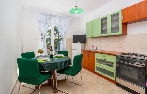a kitchen with a dining table and green chairs at 1 Bedroom Nice Apartment In Pinezici in Pinezici