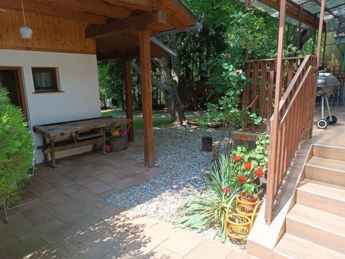 a garden with a wooden bench and a table at Dóra Apartman in Balatonszárszó