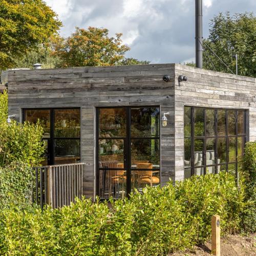 a small wooden building with black windows at Louma Country Hotel in Wootton Fitzpaine