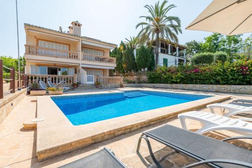 a villa with a swimming pool in front of a house at Apartment Soleado by Mallorca House Rent in Portocolom