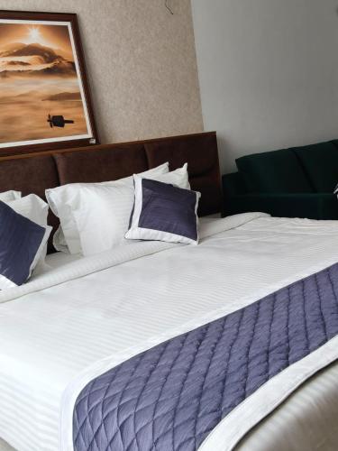 a bed with purple and white pillows in a room at SABU's GRAND ROYALE HOTEL in Trivandrum