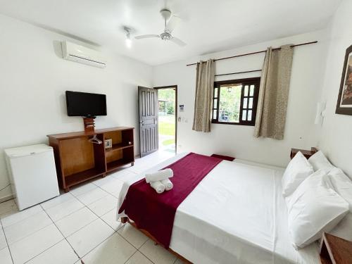 a bedroom with a large bed and a tv at SR Beach Country in Caraguatatuba