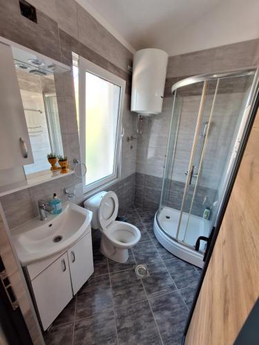 a bathroom with a toilet and a sink and a shower at Goka apartments in Gevgelija