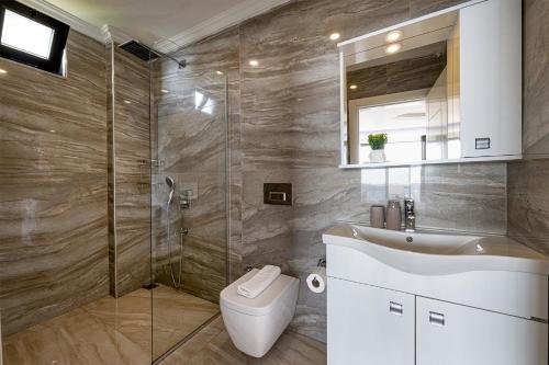 a bathroom with a shower and a toilet and a sink at Villa Upper House in Kas