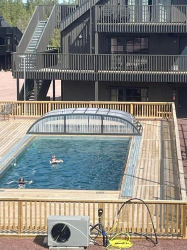 a swimming pool with two people in a building at Luxury ski apartment - Lindvallen Sälen 365 Pool & Padel concept in Lindvallen