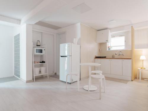 a kitchen with a white refrigerator and a table at SeogyoHueStay in Seoul