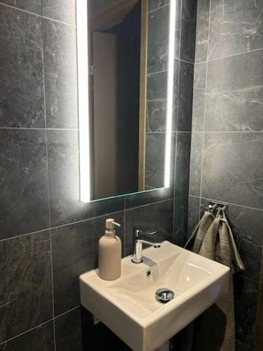 a bathroom with a white sink and a mirror at Luxury ski apartment - Lindvallen Sälen 365 Pool & Padel concept in Lindvallen