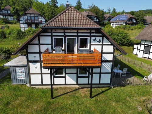 a small house with a deck on the grass at Ferienwohnung Frankenblick in Frankenau