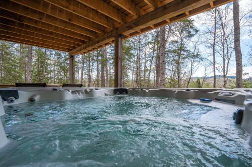a hot tub in a house with trees in the background at L'Inukshuk - Chalet en bois ave Spa in Saint-Alexis-des-Monts