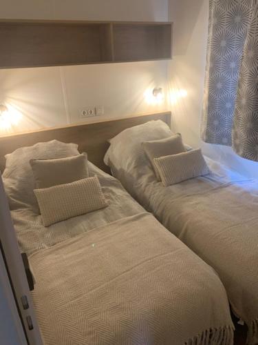 a bedroom with two beds with white sheets and pillows at Maison la Rivière in Gasselte