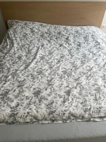 a bedsheet with a floral pattern on a bed at Jasminu apartment in Jūrmala