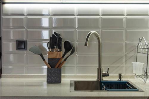 a kitchen counter with a sink with a knife holder at MaRKoS Sea View Apartment Bamboo Beach in Ts'ikhisdziri