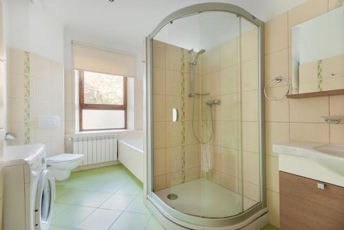 a bathroom with a shower and a toilet and a sink at Jasminu apartment in Jūrmala