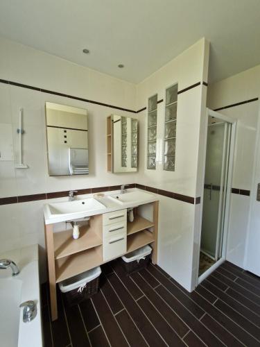 une salle de bain avec deux lavabos et un miroir dans l'établissement Beautiful Villa Landaise , pool, garden, 4 bedrooms, à Léon