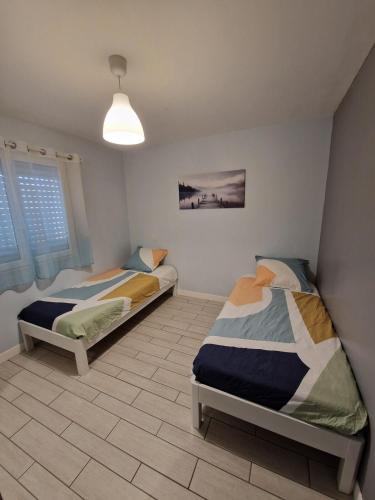 - une chambre avec 2 lits et une lampe pendant dans l'établissement Beautiful Villa Landaise , pool, garden, 4 bedrooms, à Léon