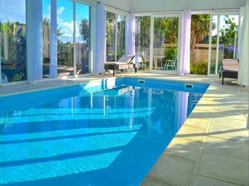 une piscine avec de l'eau bleue dans une maison dans l'établissement Villa du Port, à Sibiril