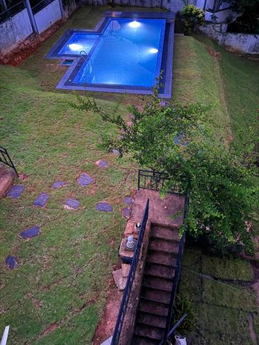 an overhead view of a swimming pool with stairs in a yard at Kandyan View Holiday Bungalow free pickup from kandy in Kandy
