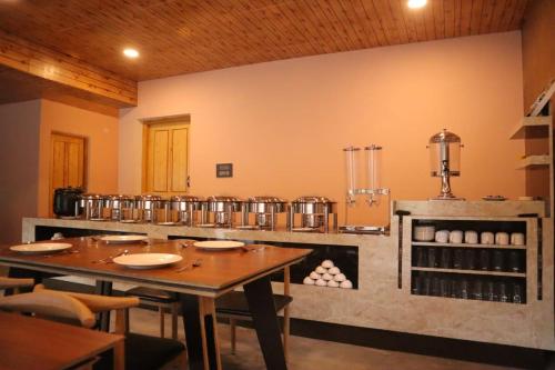 a restaurant with a table and a counter with a kitchen at The Khama in Hundar