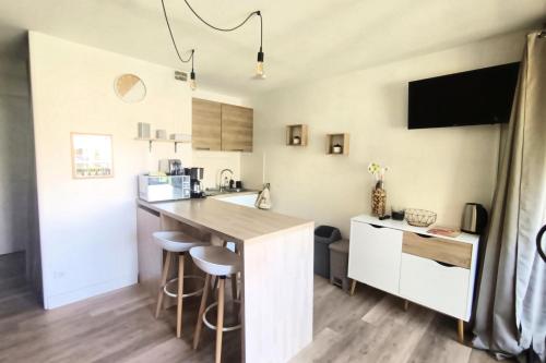 une cuisine avec un comptoir et un îlot de cuisine avec des tabourets dans l'établissement Apartment with balcony 800 meters from the sea, à Canet