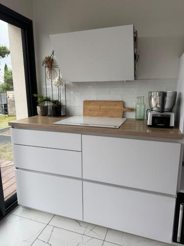 une cuisine avec des armoires blanches et un comptoir dans l'établissement Architect designed house with view, à Montrabé
