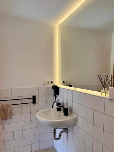 a white bathroom with a sink and a mirror at Landhaus Buckow in Buckow