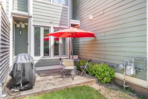 a patio with a red umbrella and chairs on a house at Blue Mountain Haus - Private Patio - Walk to Blue in Blue Mountains