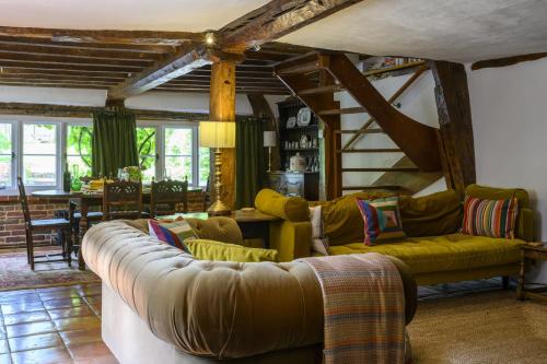ein Wohnzimmer mit Couch und Tisch in der Unterkunft Cruck Cottage in Fordingbridge