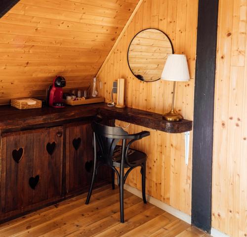 a bar in a cabin with a chair and a mirror at Legatum Cottage 