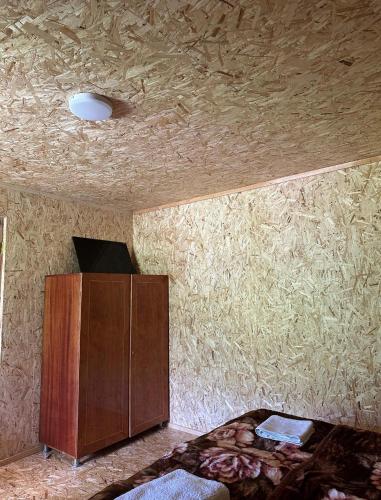 a bedroom with a bed and a ceiling with hay at Qvis Sakhli in Tvebishi