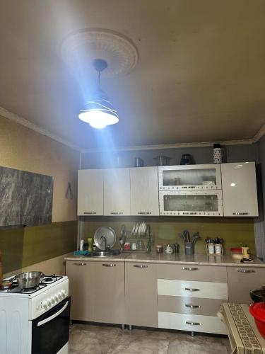 a kitchen with a white stove and a blue light at Qvis Sakhli in Tvebishi